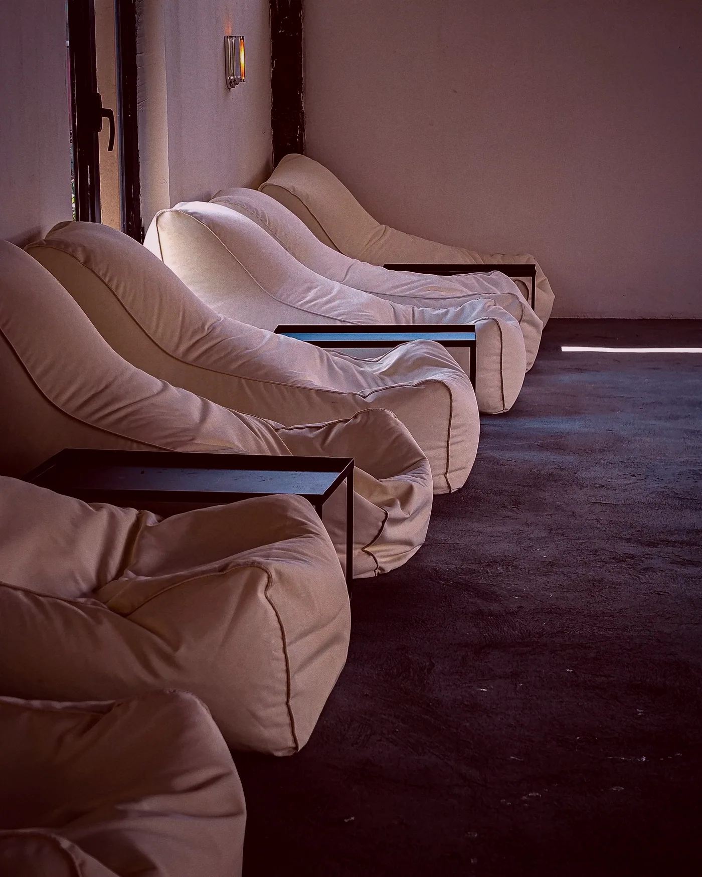 The club room with tables set out, shelves of boxed games along the wall and warm lamps